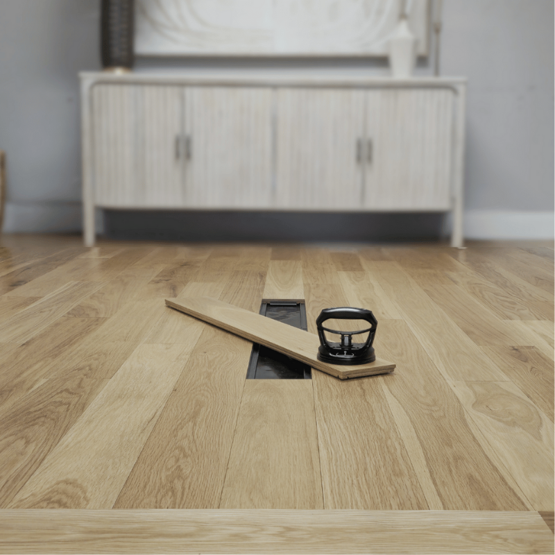 A single plank is removed from a Steller solid wood floor for repairs