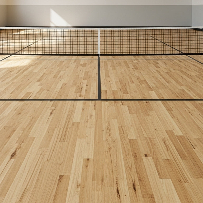 Indoor pickleball court with wooden floor and net setup